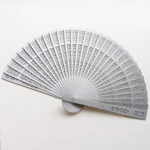 Detail view of an elegant hollowed-out wooden folding fan with intricate floral patterns