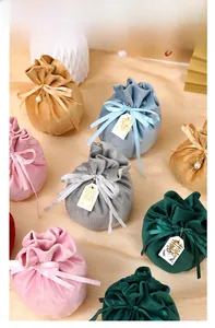 Detailed view of assorted velvet wedding favor bags with ribbon bows and charms