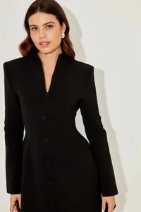 Dettaglio ravvicinato di un abito blazer nero strutturato con bottoni eleganti