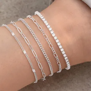 Detailed close-up of a silver waterproof Cuban and paperclip link anklet set on skin