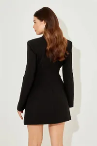 Vista posteriore di un elegante mini abito nero aderente con maniche lunghe e cuciture