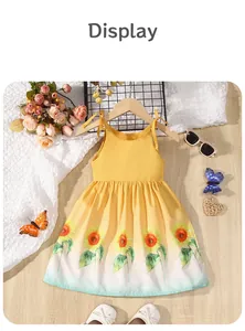 Detailed view of yellow girl's summer dress with vibrant sunflower prints and tie straps