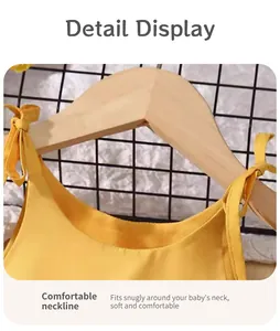 Close-up of the comfortable round neckline and adjustable shoulder ties of the girl's yellow dress.