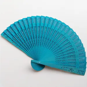 Detailed shot of a vibrant blue hollow-carved wooden folding fan with intricate filigree.