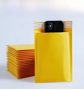 Dettaglio della capacità della busta imbottita in carta kraft gialla con uno smartphone