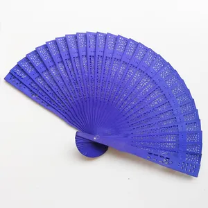 Detail view of royal blue wooden folding fan with intricate floral hollow-out patterns