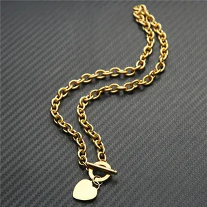 Détail de la chaîne O en acier doré avec pendentif cœur et fermoir à bascule en T.