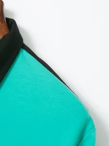 Macro close-up detail of a teal men's cotton polo shirt featuring a black turn-down collar