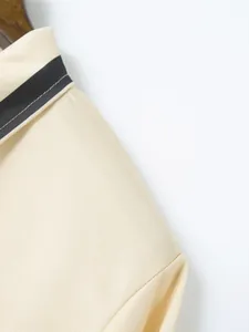 Close-up of beige men's polo shirt featuring pique fabric texture and striped collar detail