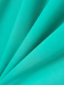 Close-up detail of soft teal twill cotton fabric texture for men's polo shirt