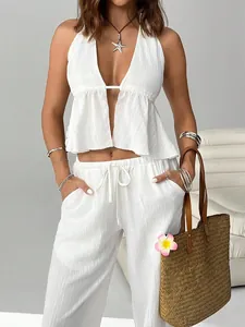 White halter top and wide-leg pants set with summery straw bag and starfish necklace.