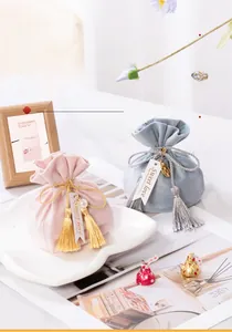 Close-up of elegant pink and blue velvet drawstring gift bags with tassels and tags