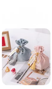 Detail of elegant velvet drawstring wedding gift pouches with tassels and Sweet Love tags