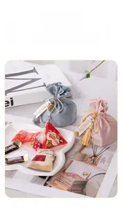 Close-up of velvet drawstring wedding favor bags with tassels and sweet love tags