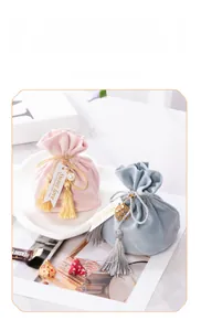 Elegant velvet wedding favor candy bags with gold tassels and pearl charms for guests
