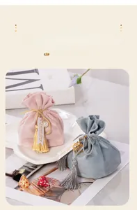 Detail view of elegant velvet wedding candy bags with tassels and tags.