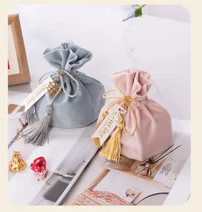 Detailed view of elegant velvet wedding favor bags with silk tassels and Sweet Love tags