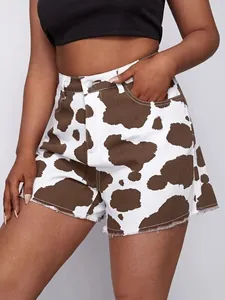 Detailaufnahme der Damen-Jeans-Shorts mit hohem Bund, Kuhmuster und ausgefranstem Saum