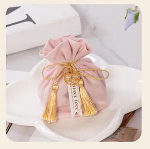 Detailed view of pink velvet wedding favor bag featuring gold tassels and sweet love tag