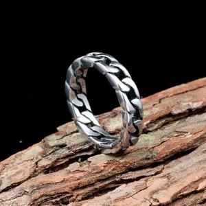 Maskuliner Vintage-Edelstahlring im Kettendesign auf natürlichem Rindenhintergrund