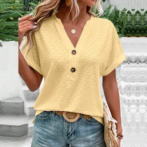 Close-up detail of the yellow eyelet fabric and V-neckline with decorative buttons