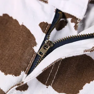 Makrodetail des Metallreißverschlusses und des Kuhmusterstoffs bei Damen-Jeansshorts
