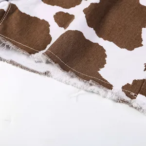 Makroansicht des ausgefransten Saums und Materialdetails bei Denim-Shorts mit Kuhmuster