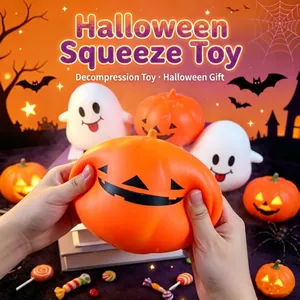Gros plan de mains pressant un jouet squishy citrouille d'Halloween pour déstresser.