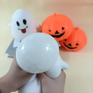 Gros plan d'une main pressant un jouet squishy fantôme d'Halloween doux et relaxant
