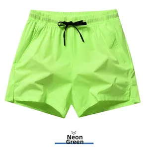 Front view detail of neon green men's quick-dry sports shorts with elastic drawstring waist