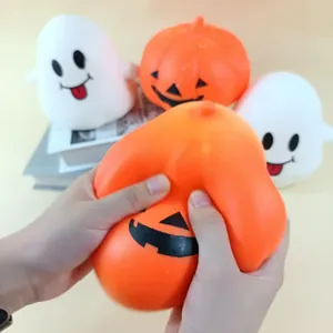Détail de mains pressant un jouet squishy citrouille d'Halloween pour décompresser