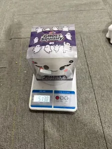 Détail d'un jouet squishy fantôme d'Halloween blanc pesé sur une balance numérique.