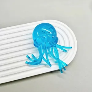 Giocattolo squishy medusa blu traslucido per alleviare lo stress su vassoio bianco.