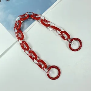 Close-up detail of the two-tone red and clear acrylic chain strap for bag decoration