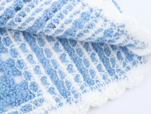Gros plan détaillé sur la texture en maille crochetée bleu et blanc à motif ajouré
