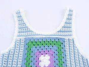 Détail rapproché d'un haut au crochet coloré avec une encolure festonnée et des motifs.