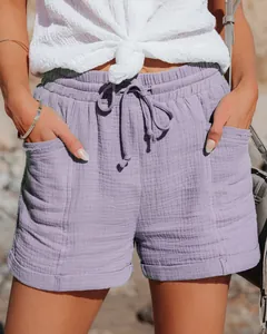 Vista dettagliata dei pantaloncini viola a vita alta con coulisse e texture in cotone