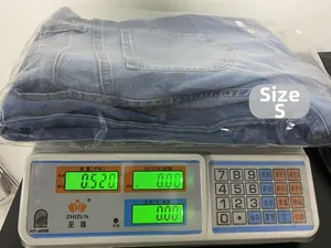 Weight of blue high-waist straight leg jeans in size S shown as 0.52kg on a scale