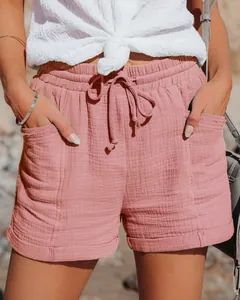 Dettaglio dei pantaloncini rosa a vita alta con coulisse e tessuto strutturato.