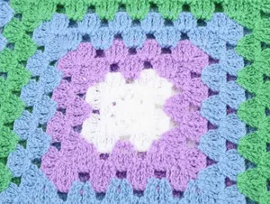 Détail rapproché montrant le motif de crochet multicolore complexe sur ce haut