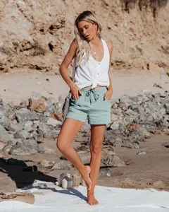 Dettaglio degli shorts verde menta con coulisse e del top bianco con nodo al mare.