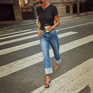Stylish high-waisted straight leg cuffed denim jeans for women in casual street setting.