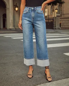Detailed view of high-waisted straight-leg jeans with wide cuffed hems in blue denim.