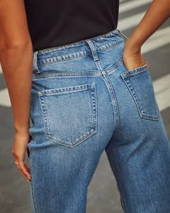 Detailed macro view of high-waisted vintage blue straight-leg denim jeans back pockets