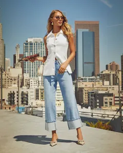 High-waisted light blue wide-leg denim jeans with stylish large cuffed hems on city rooftop