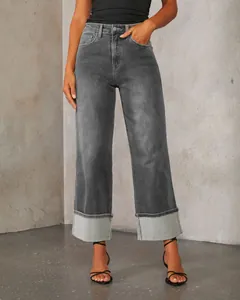 Detail view of gray high-waisted straight jeans with stylish wide rolled cuffs design.