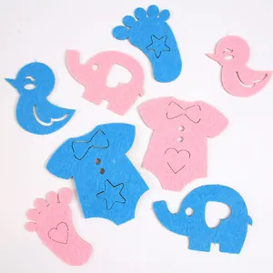 Blue and pink felt gender reveal stickers with baby onesie, elephant, and footprint shapes