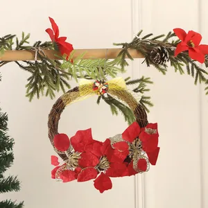 Detailed view of a festive Christmas rattan wreath with red poinsettias and golden mesh bow
