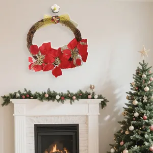 Festive Christmas wreath with red poinsettias and gold bow on a white wall