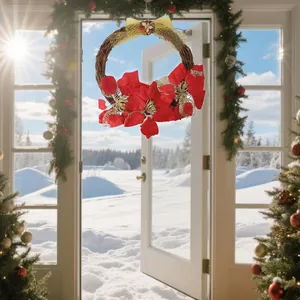 Festive Christmas wreath with red poinsettias hanging on a white door in a snowy scene.